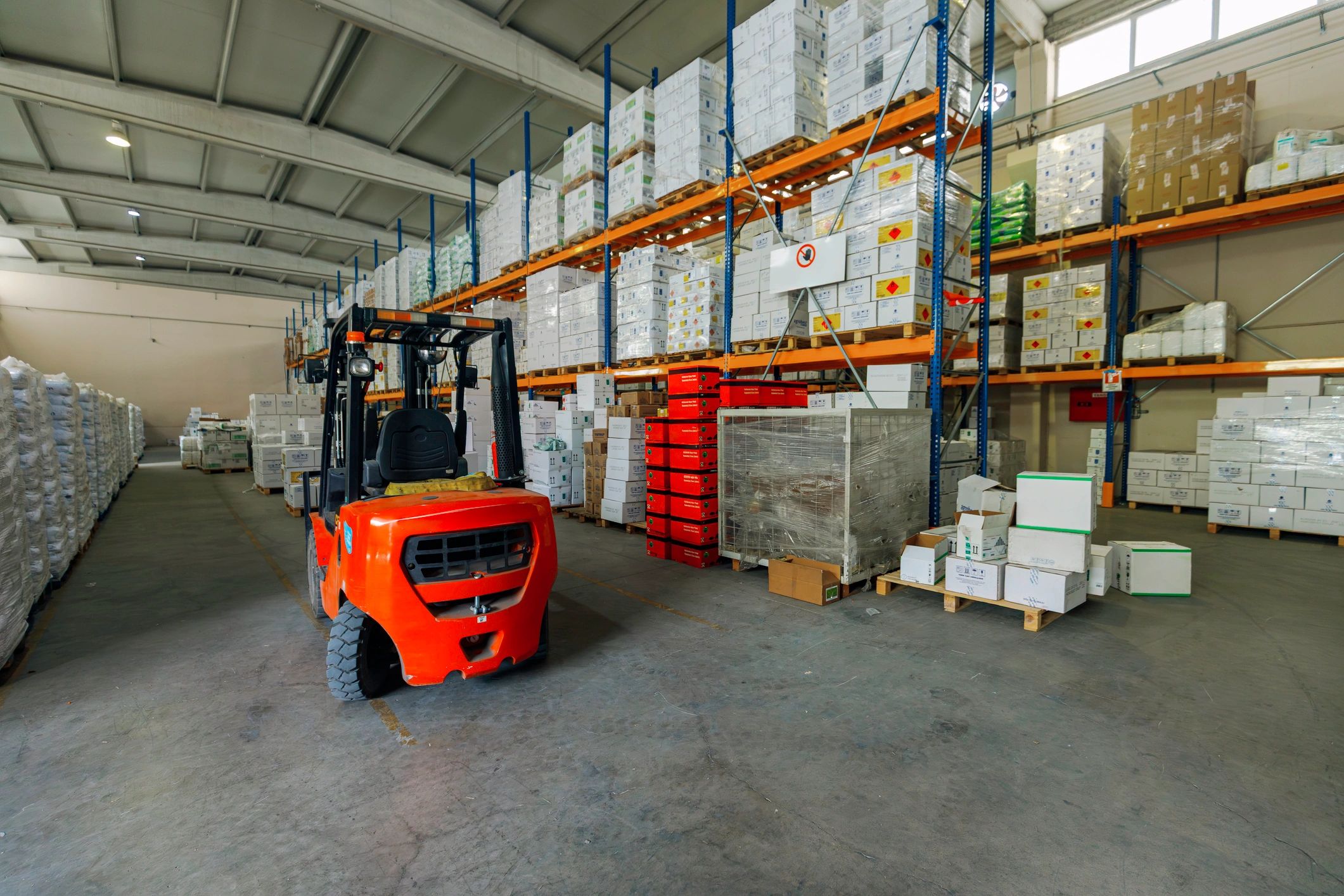 Industrial forklift operating in a warehouse aisle